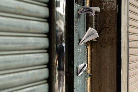Weathered communal letterboxes with overflowing mail on a residential building entrance in Mong Kok, Kowloon, Hong Kong, labelled with Chinese-language flat identifiers (translations: 5C, 6A, 6B)
