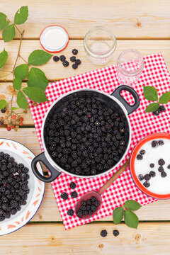 Preparation of fresh blackberry jam on a wooden table