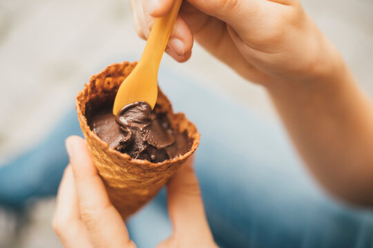 Woman's hand holding ice cream cone with cholocolate ice, close-up