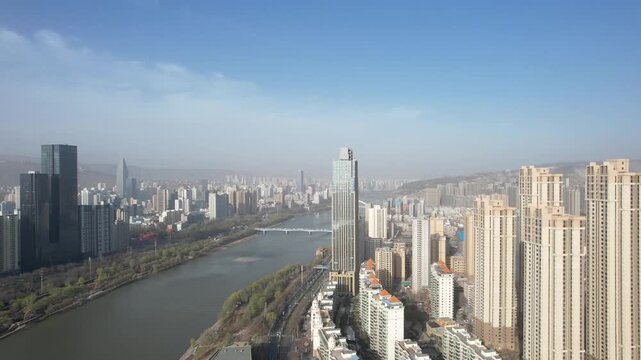 4K aerial footage of Yellow River through Lanzhou city skyline
