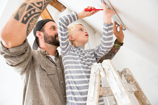 Father and son working on loft conversion using water level