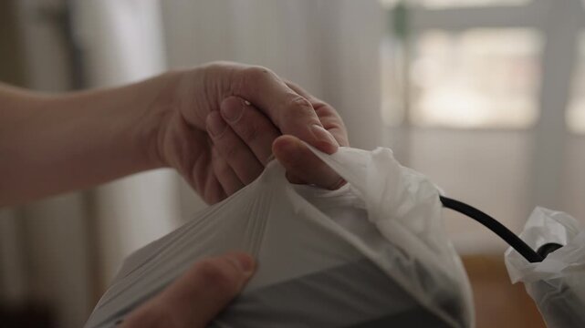 Close-up of unrecognizable person hands unwrapping brand new electronic device from its protective packaging, unboxing modern gadget for home, office technology setup. Shooting in slow motion