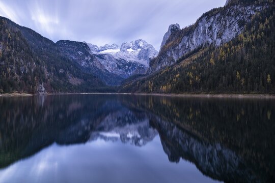 The Vordere Gosausee lake in autumn with a view of the Dachstein mountain range. The Gosaukamm on the right. Cloudy sky. Reflection. Long exposure. Vorderer Gosausee, Gosau, Gosau valley, Salzkammergut, Upper Austria, Austria