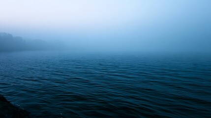 Fototapeta premium A vast expanse of blue sea shrouded in diffused misty light creating a serene and exploratory mood