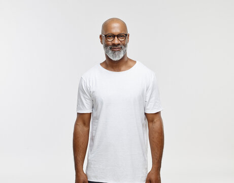 Portrait of smiling bald man with beard wearing spectacles and white t-shirt