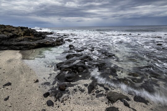 Waves blaze on the beach, rocky coast with volcanic stones, long exposure, Playa de la Peque&ntilde;a, Punta Usaje, Lanzarote, Canary Islands, Spain