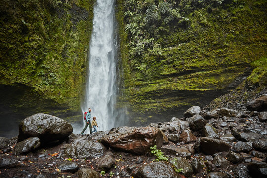 Chile, Patagonia, Osorno Volcano, mother and son walking at Las Cascadas waterfall