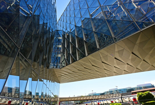 Geneva, Switzerland, Europe :  05.2026 : Japan International Tobacco headquarters building, Stadler trains in Geneve-Secheron station, pedestrian passage above rails leading to Maison de la Paix