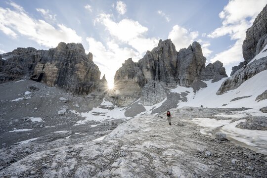 Ascent in a rocky mountain landscape with steep rocky peaks to Bocca degli Armi, Sun Star, Brenta Mountains, Brenta-Adamello Natural Park, Trentino, Italy