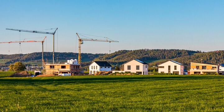 Modern houses and cranes at construction site in rural Germany
