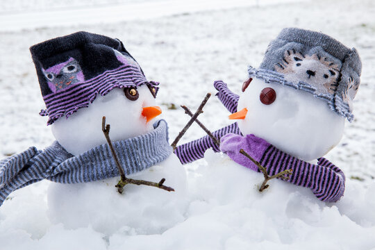 Two cute snowmen friends embracing