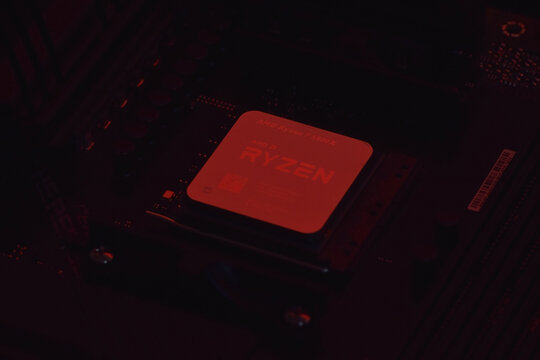 A close-up of an AMD Ryzen 7 5800X processor in a packaging box with backlit keyboards in the background.