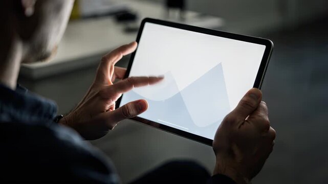 Investor interacting with an investment app on a tablet focusing on asset allocation for tax efficiency with the tablet screen sharply contrasted against the blurred surroundings.