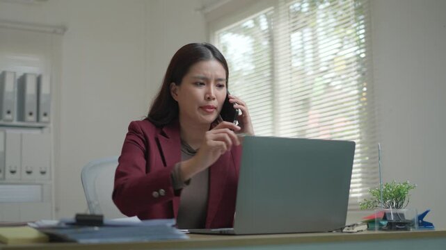 Frustrated professional asian woman arguing on a smartphone call. Upset manager discussing a work problem with an angry expression
