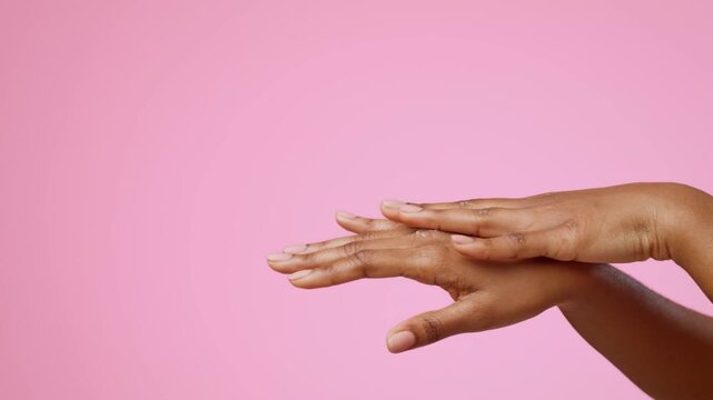 Focused Hands Of Black Woman Applying Moisturizing Cream To Skin With Care, Showcasing Skincare Routine At Home, In Cozy Setting. Unrecognizable, Emphasizing Self-care And Beauty Concept