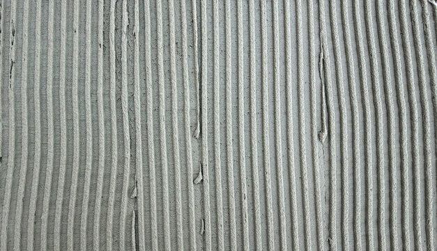 Textured gray cement surface with parallel grooves and ridges