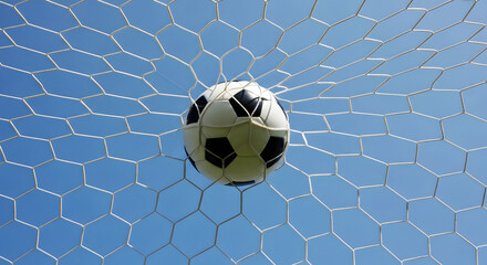 Fototapeta premium Soccer ball caught in white net against clear blue sky goal sport