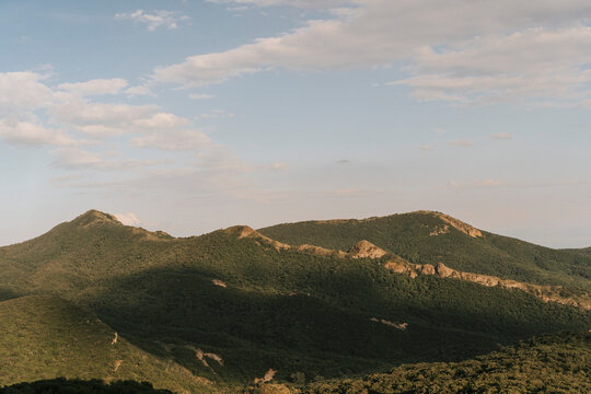 Scenic rolling green mountains under a soft evening sky.