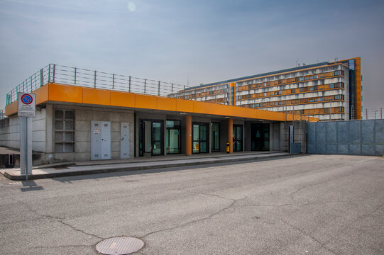 Complesso architettonico moderno con facciata in cemento e vetro, dettagli gialli e area esterna pavimentata. Ideale per concetti di architettura contemporanea, edifici istituzionali e design urbano.