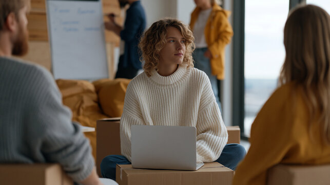 Founding team conducting impromptu retrospective on floor of half-unpacked new office, cardboard boxes serving as backrests, someone facilitating on whiteboard propped against