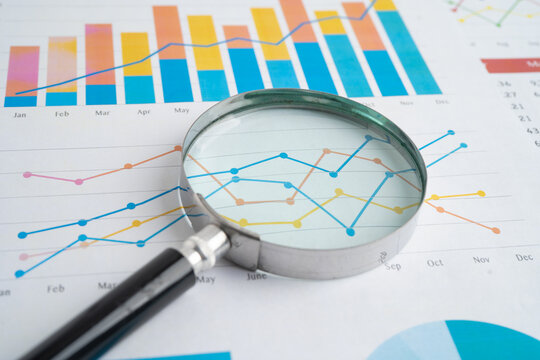 Magnifying glass on spreadsheet and graph paper. Financial data economy, Business.