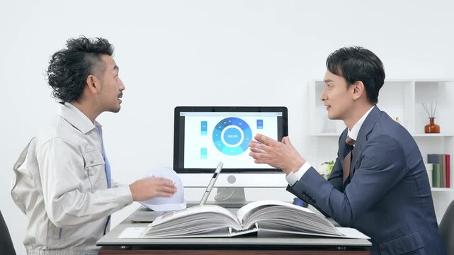 オフィスで会議するビジネスパーソンと作業員のグループ