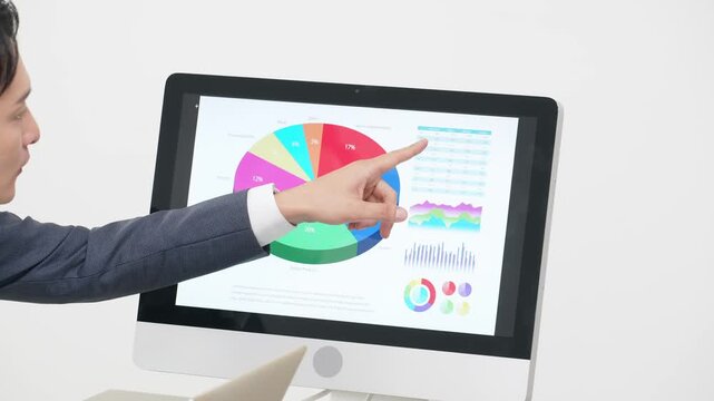 オフィスでPCを見ながら仕事する男性ビジネスパーソン