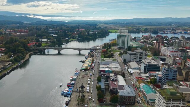 Aerial view dolly in of the city of Valdivia, with its river fair and the bridge over the Calle Calle River, establishing