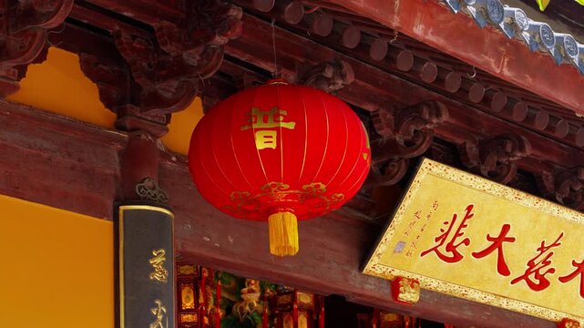 Red Chinese lantern hanging outside traditional building with ornate wooden beams