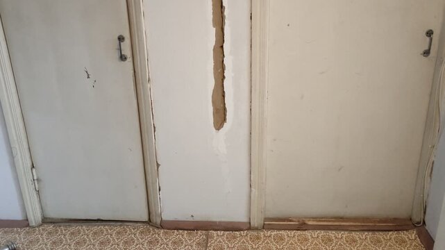 Old interior room doors with damaged wood and peeling paint, camera rises from bottom to top