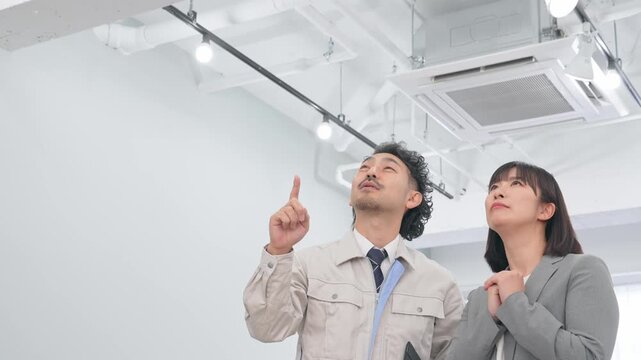 オフィスの天井設備を点検する作業員