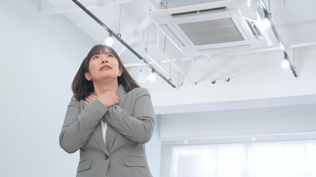オフィスで凍える女性ビジネスパーソン