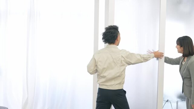 ガラスパーティションを修理する作業員