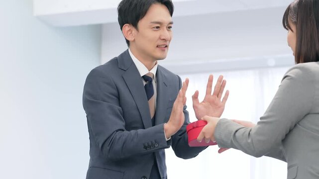 プレゼントを渡されて拒否するビジネスパーソン