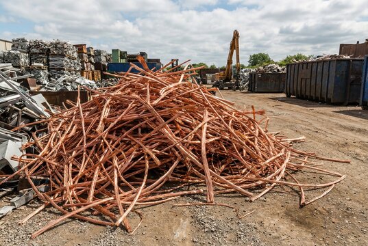 Stripped bare copper wires piled in a scrap metal recycling yard setting