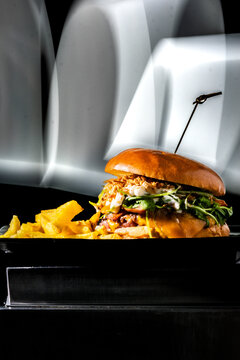 Gourmet burger with brioche bun, arugula, and fries