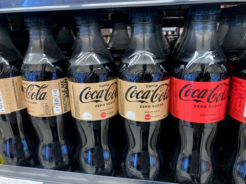 coca cola zero sugar vanilla and regular plastic bottles on a supermarket shelf