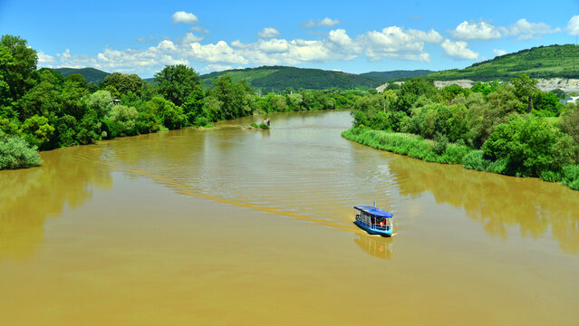 A tourist boat on the Mures River, near Deva, on a sunny summer day in Transylvania.