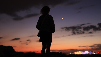 Obraz premium Silhouette of a woman looking at blue hour morning - evening skies with planet Venus.