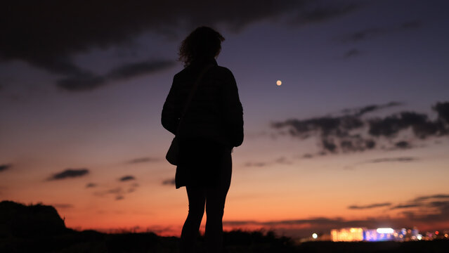 Silhouette of a woman looking at blue hour morning - evening skies with planet Venus.