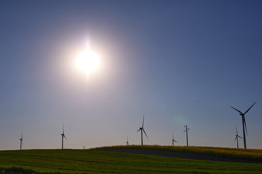 Wind turbines at sunset in green field &ndash; renewable energy, clean power, sustainable future.