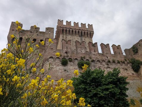 Imponente castello in pietra con torri merlate e mura storiche sotto un cielo grigio, per un&rsquo;atmosfera medievale forte e suggestiva