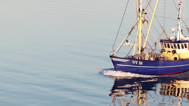 Fishing trawler ship sailing on calm ocean water