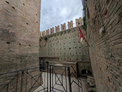 Imponente castello in pietra con torri merlate e mura storiche sotto un cielo grigio, per un&rsquo;atmosfera medievale forte e suggestiva
