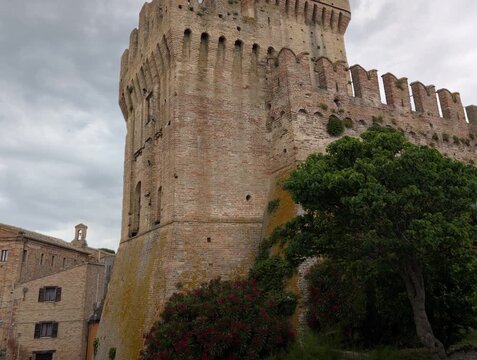Imponente castello in pietra con torri merlate e mura storiche sotto un cielo grigio, per un&rsquo;atmosfera medievale forte e suggestiva