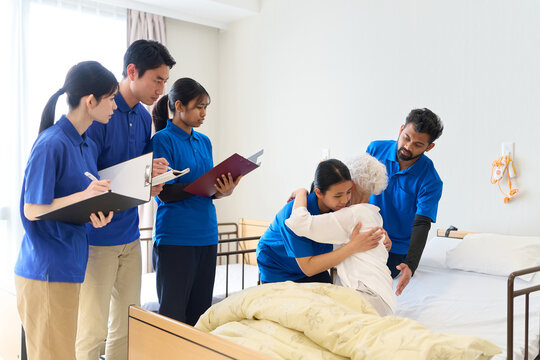 介護施設で介助の指導をする東南アジア人介護士