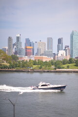 Fototapeta premium Riverfront city skyline with speedboat