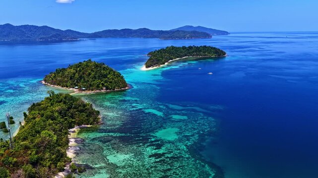 Breathtaking wide drone shot over Port Barton, Palawan, Philippines. Features a chain of lush green tropical islands surrounded by spectacular turquoise coral reefs and deep blue ocean waters.