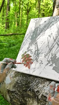 A gloved hand paints a fern branch with a brush. Highlights the delicate balance between control and spontaneity in Natural Brush Painting
