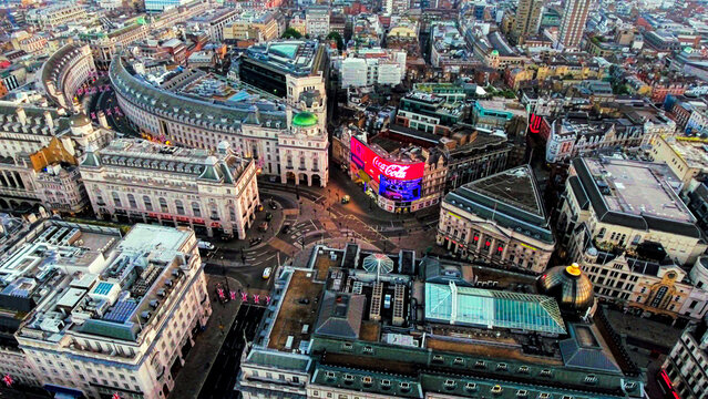 Aerial drone view of Piccadilly Circus and Regent Street Quadrant with illuminated LED advertising screens and Union Jack flags, London, England, dusk
